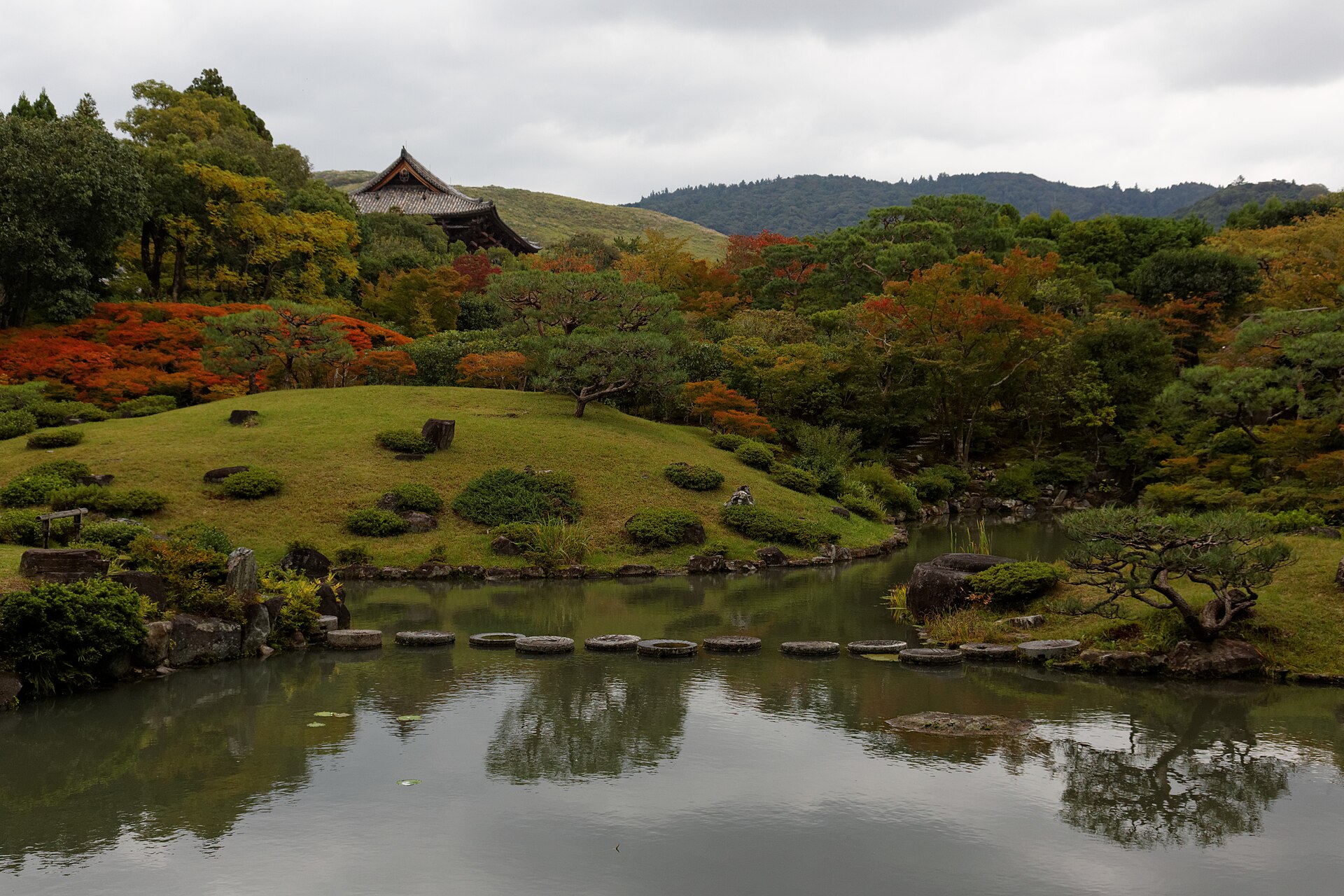 El estanque del jardín Isuien y sus pasaderas, con el tejado de la gran puerta del Tōdai-ji
