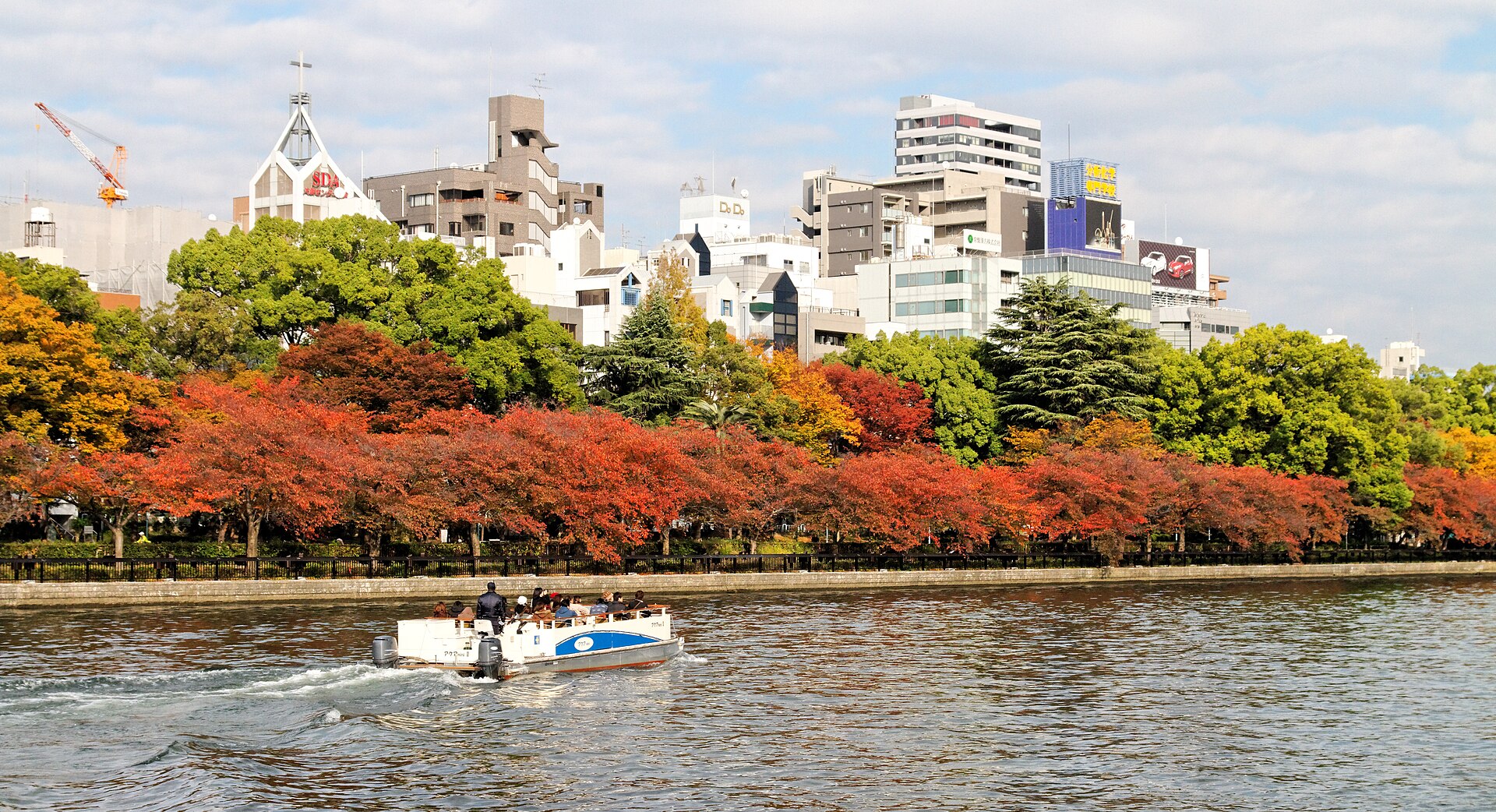 Un barco turístico junto a la isla de Nakanoshima en otoño