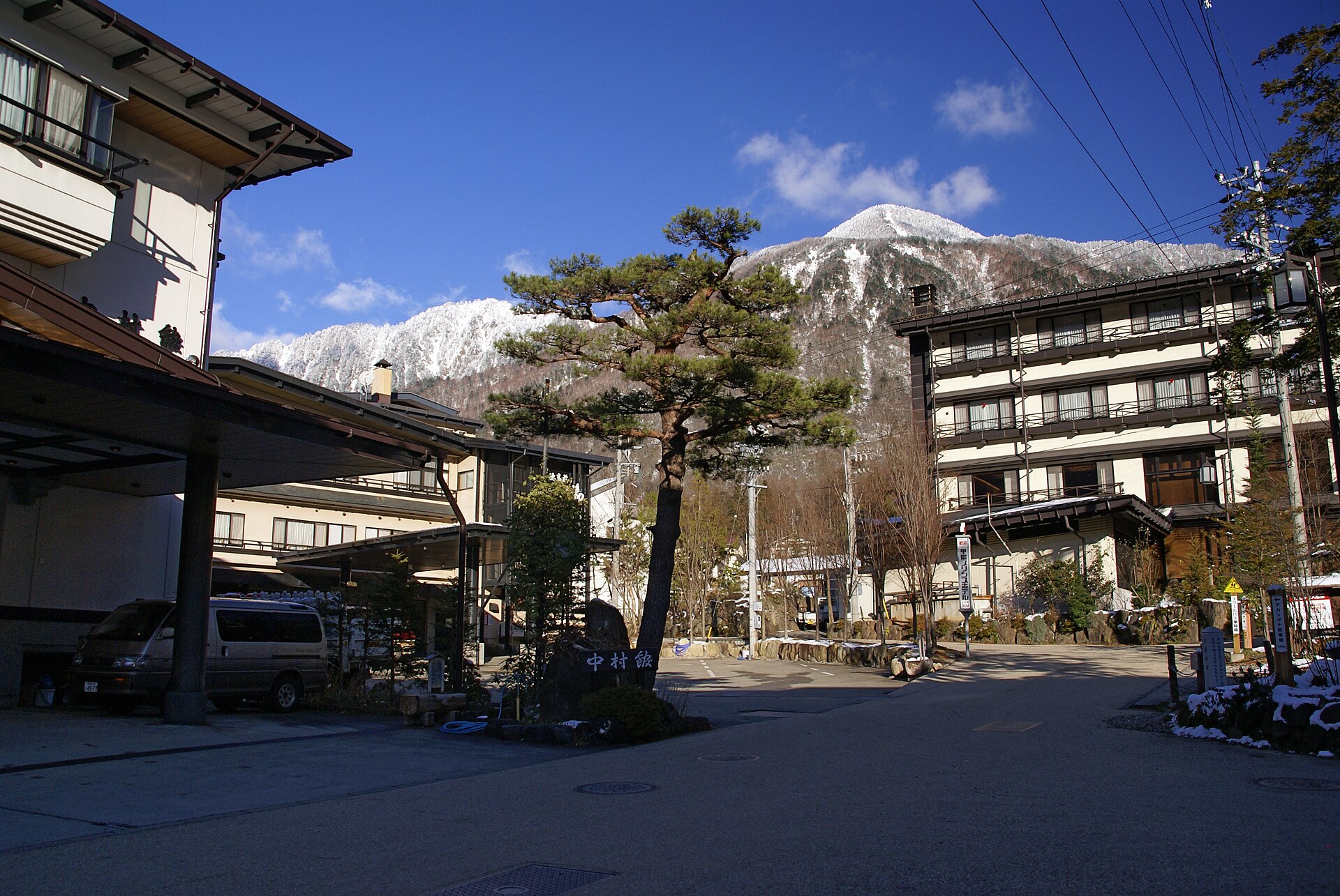 Een straat in Hirayu Onsen, met zicht op besneeuwde toppen